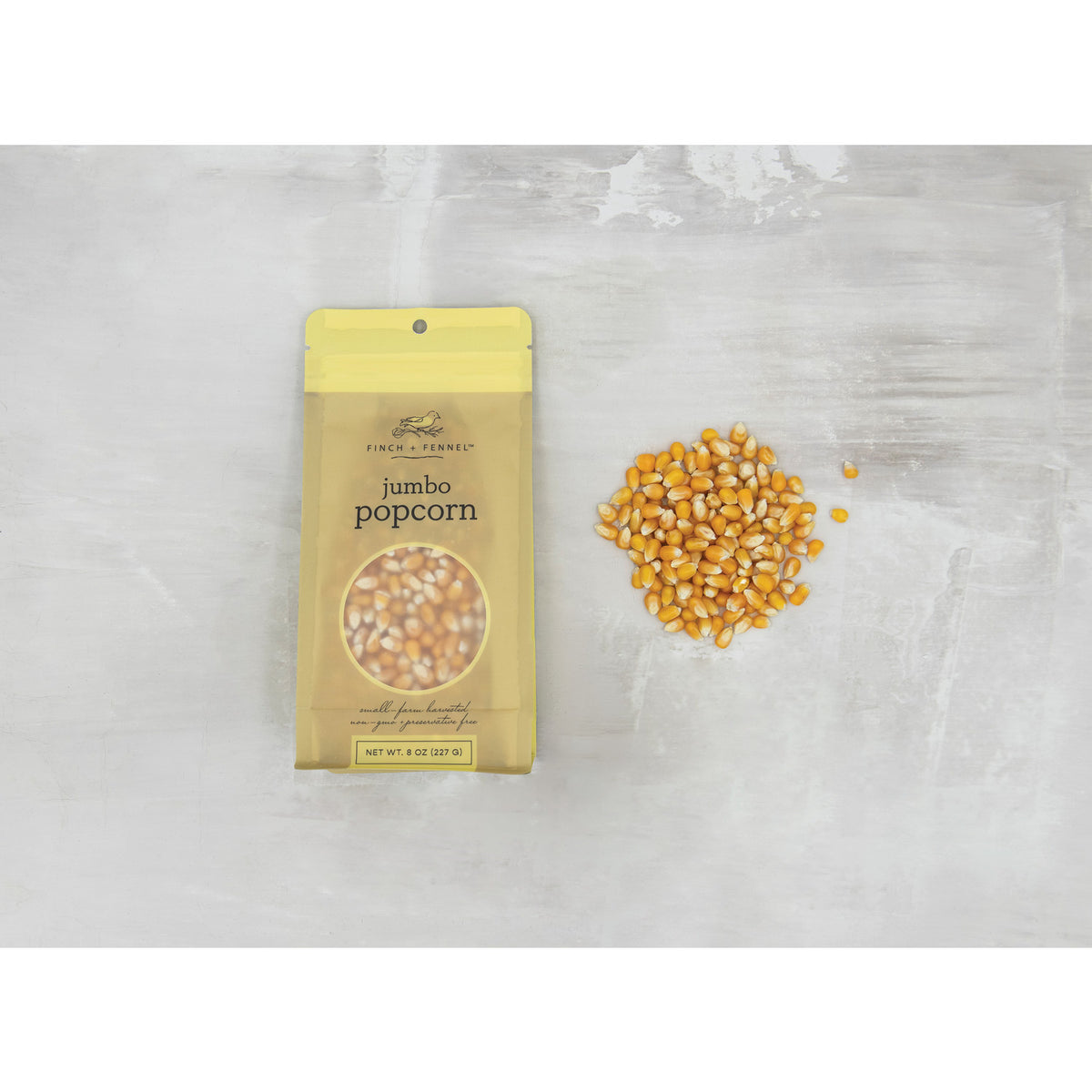 Fisher & Ferman jumbo popcorn package with unpopped kernels on a light gray background