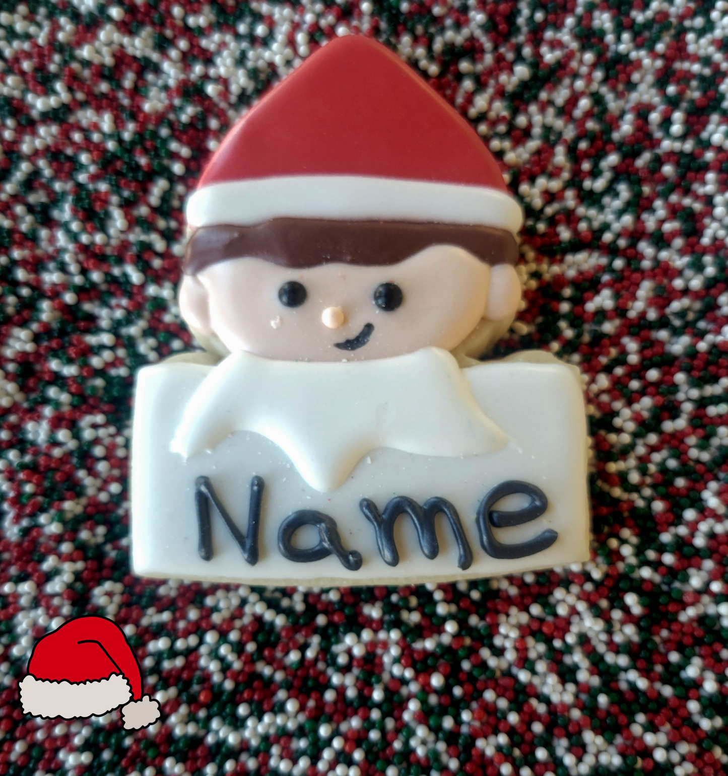 Christmas-themed cookie with a child wearing a Santa hat and a 'Name' label on a textured background.