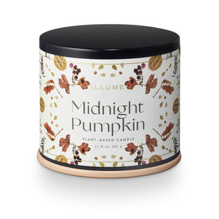 A cylindrical candle tin labeled 'Midnight Pumpkin' by Illume, with a black lid, cream label, and autumn-themed botanical illustrations including pumpkins, leaves, and berries, shown on a white background.