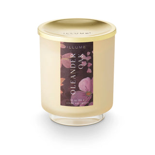 Candle with a gold lid and floral label on a white background