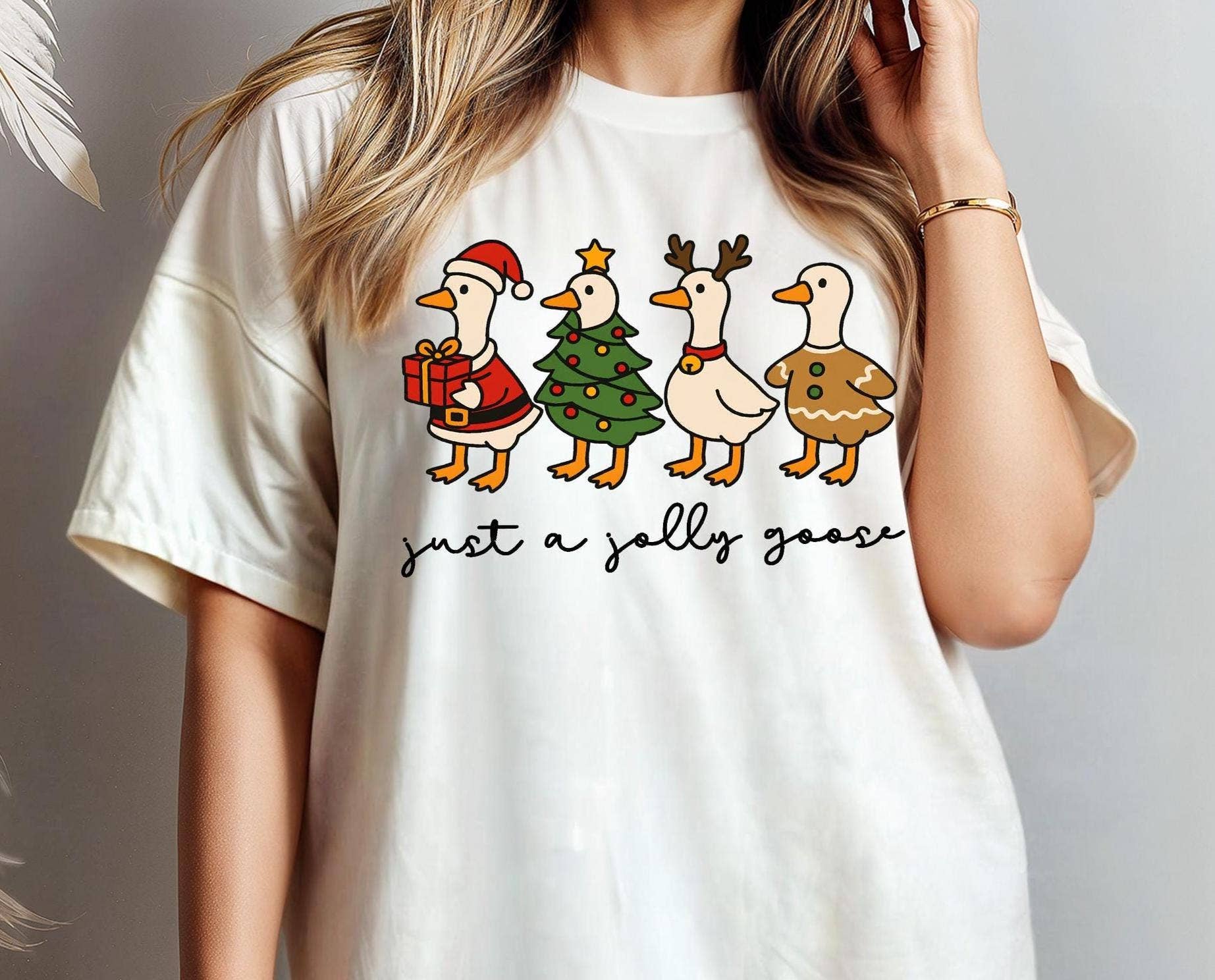 White t-shirt with Christmas-themed graphic and text worn by a person.