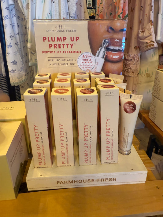 Farmhouse Fresh Plump Up Pretty lip treatment products on a wooden shelf.