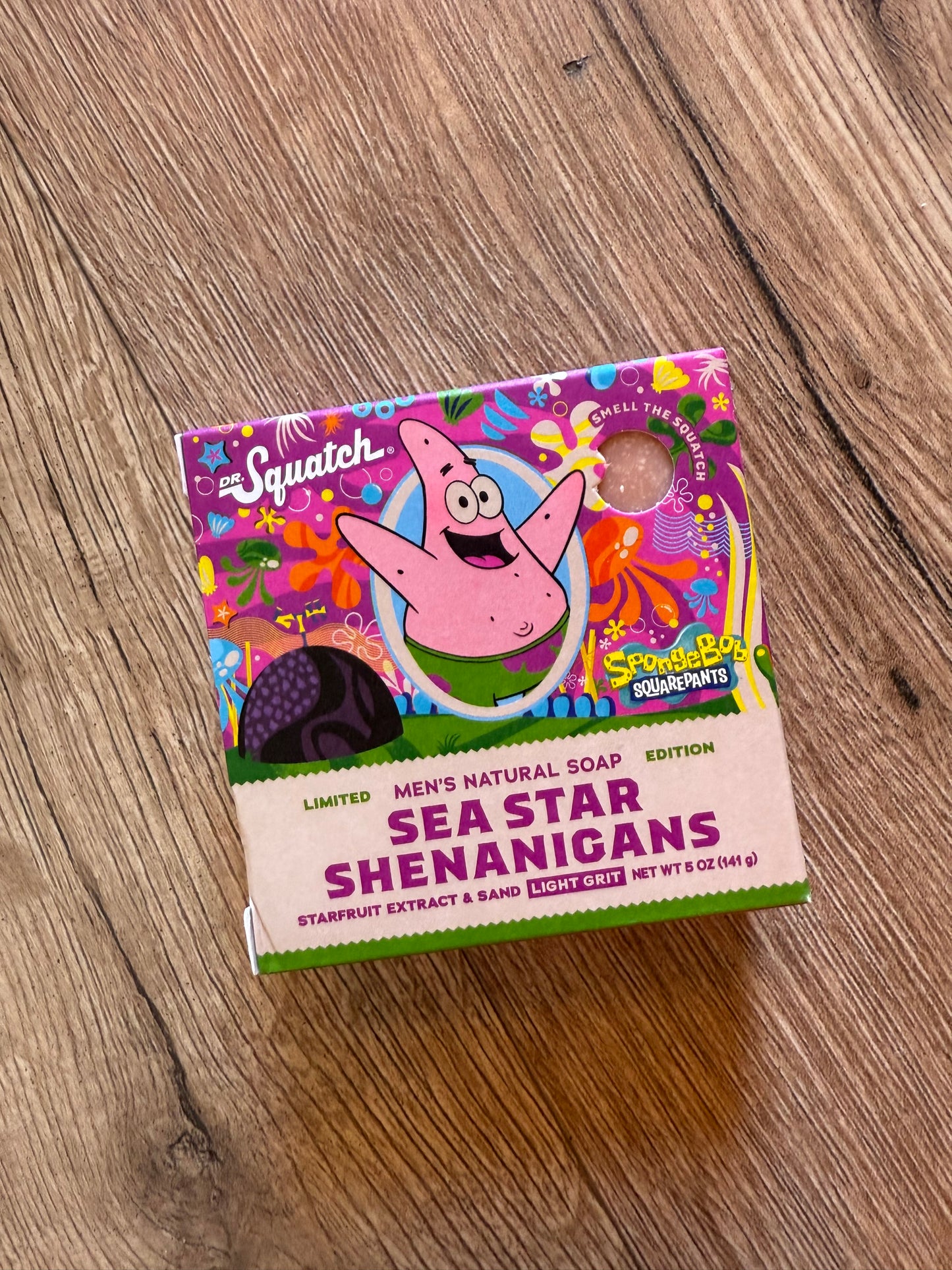 Colorful box of Men's Natural Soap with a cartoon character on a wooden surface