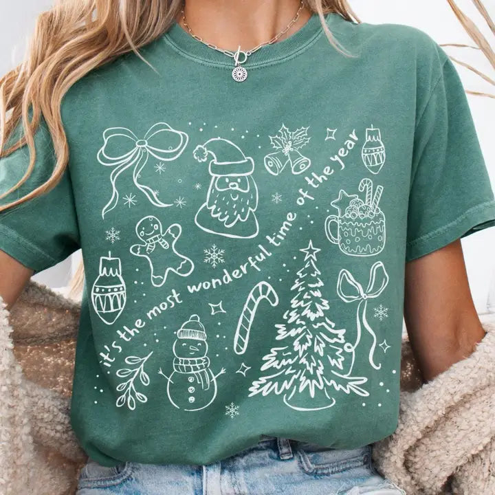 Green t-shirt with Christmas-themed designs and text worn by a person.